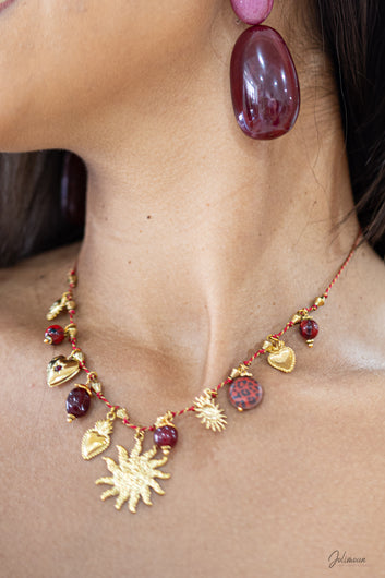 Iséria - Collier doré multi breloques soleil sur fil rouge